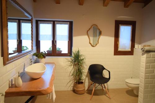 a bathroom with a sink and a chair and windows at Batxillerenea in Doneztebe