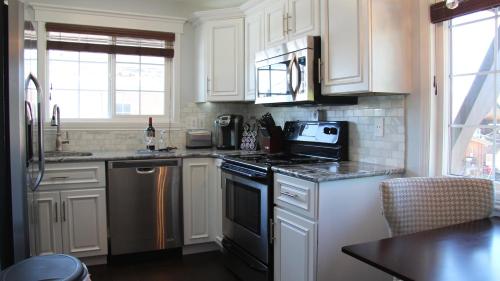 a kitchen with white cabinets and a black stove top oven at The New Yorker in Whitefish