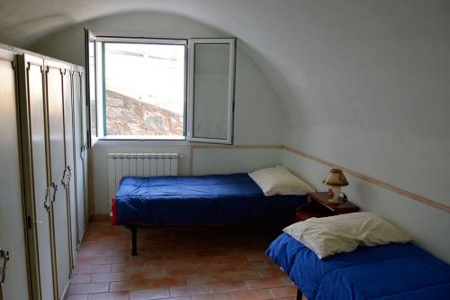 two beds in a room with a window at Casa Delle Olive in Dolceacqua