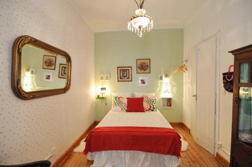 a bedroom with a bed and a mirror at Casa do Jardim in Silves