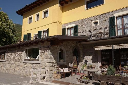 un bâtiment jaune avec une table et des chaises devant lui dans l'établissement Hotel Gabriella, à Fanano