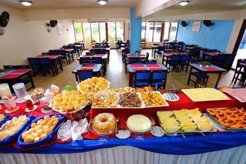 a buffet of food on a table in a cafeteria at Boulevard da Praia Apart Hotel in Porto Seguro