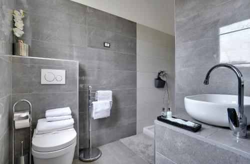 a bathroom with a sink and a toilet and a tub at Villa B&B Marina & Parking Free in Rovinj