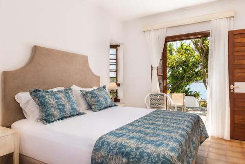 um quarto com uma cama e uma grande janela em Alianthos Villa em Tersanas