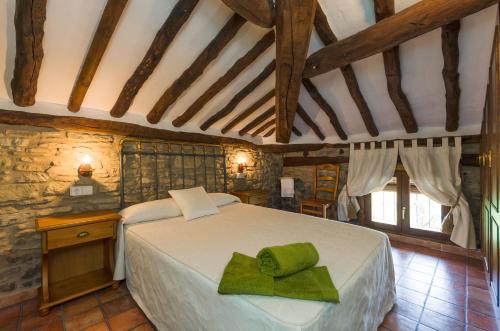 a bedroom with a bed with a green towel on it at Casa Trallero in Almazorre