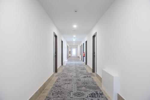 an empty corridor with white walls and a carpeted hallway at K-Apart Hotel & Boardinghouse in Hürth