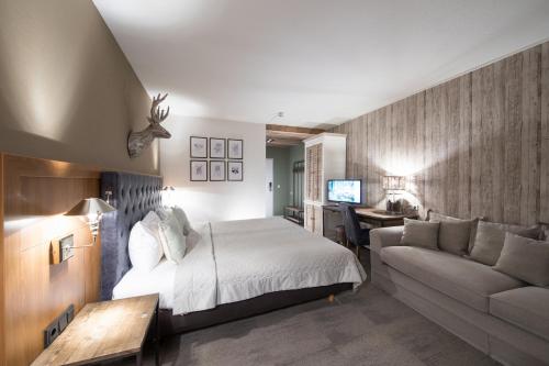 een slaapkamer met een bed, een bank en een bureau bij Bilderberg Hotel 't Speulderbos in Garderen