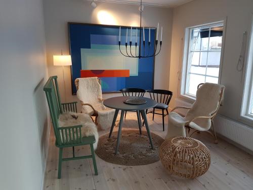 a dining room with a table and chairs and a painting at Hotel Akerlund in Jokkmokk