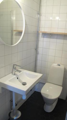a white bathroom with a sink and a toilet at Hotel Akerlund in Jokkmokk