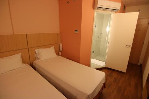 a small room with two beds and a bathroom at Samba Itaboraí in Itaboraí