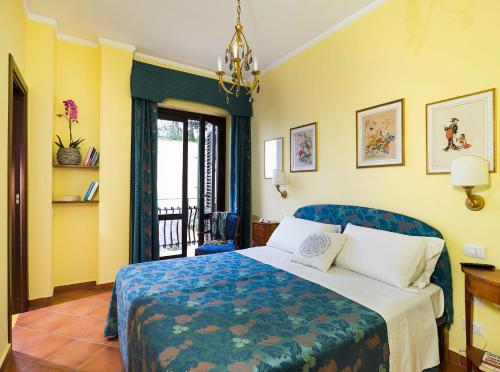a bedroom with a bed with a blue and yellow wall at Hotel Sirius in Taormina