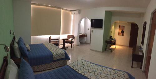 a hotel room with two beds and a living room at Hotel Palacio in Córdoba
