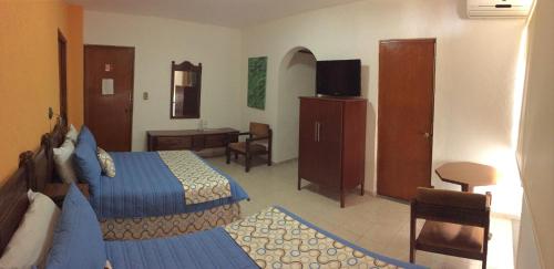 a hotel room with two beds and a desk at Hotel Palacio in Córdoba
