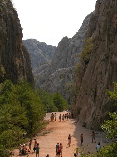 a group of people walking down a dirt road in a canyon at Guesthouse Neven Paklenica in Starigrad-Paklenica