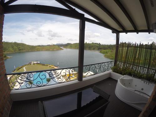 a balcony with a tub and a view of a river at Hotel La Magdalena Adult Only in Guatapé