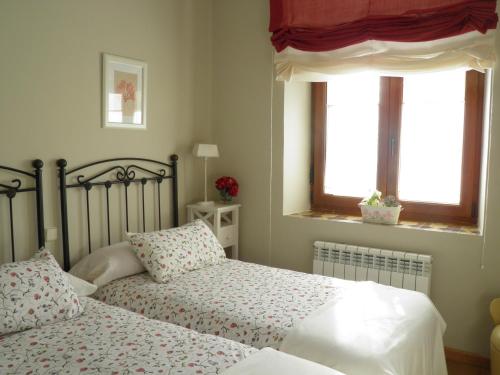 a bedroom with two beds and two windows at Casa Rural Reposo de Afanes in Muñogalindo
