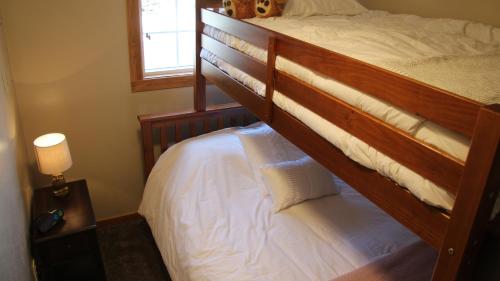 een slaapkamer met een stapelbed met witte lakens bij Cowboy Condo in Whitefish