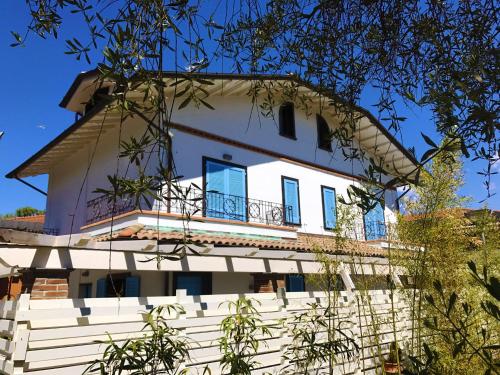 a white house with a balcony on top of it at CYTRUS rooms in Marina di Massa