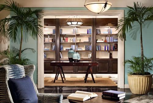 a library with a table and a book shelf with books at Half Moon in Montego Bay