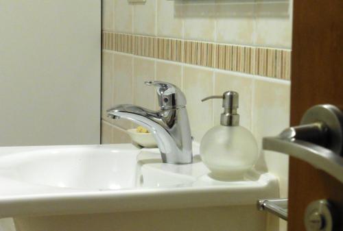 a bathroom sink with a faucet and a soap container at Casa Playa de Balares in Ponteceso