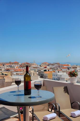 a table with two glasses of wine on a balcony at Paradise in Ermoupoli
