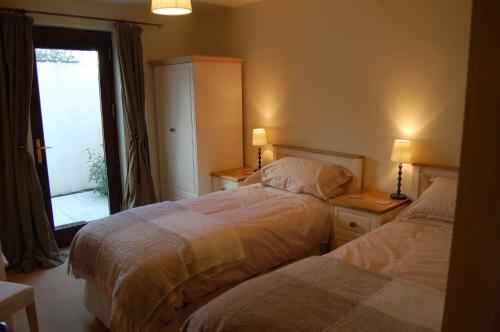 a bedroom with two beds and a window and two lamps at Apartment 2 The Waterfront in Portaferry