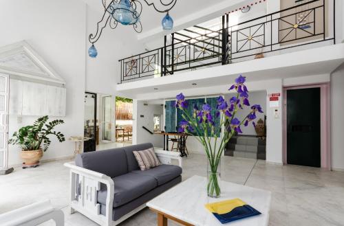 a living room with a couch and a table with purple flowers at Happiness Apartments in Hersonissos