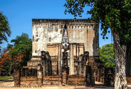 a building with a mask on top of it at Thanawong Pool Villa in Sukhothai