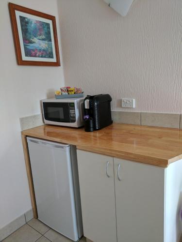 a microwave sitting on top of a wooden counter at Lake Bolac Motel in Lake Bolac