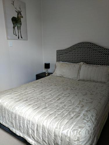 a bedroom with a white bed with a deer picture on the wall at Lake Bolac Motel in Lake Bolac