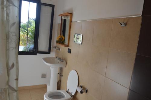 a bathroom with a toilet and a sink at Casa Cora in Villa Carlos Paz