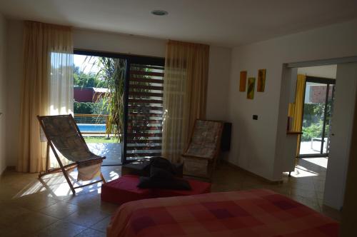 a bedroom with two chairs and a bed and a window at Casa Cora in Villa Carlos Paz