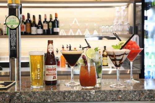 a bar with three cocktails and two bottles of beer at Mantra Club Croc in Airlie Beach