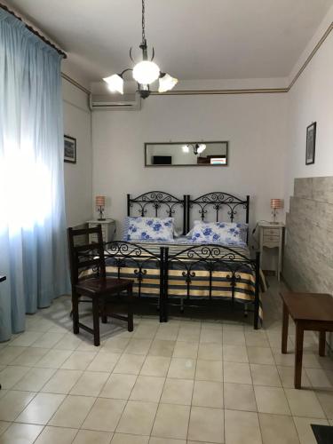 a bedroom with a bed and two chairs and a table at Albergo Europa in Marina di Mancaversa