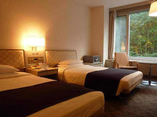 Postel nebo postele na pokoji v ubytování Shin Furano Prince Hotel