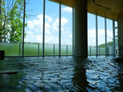 a room with a pool of water with windows at Shin Furano Prince Hotel in Furano