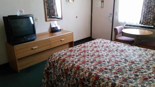 a hotel room with a bed and a tv at Economy Inn Motel in Sylmar