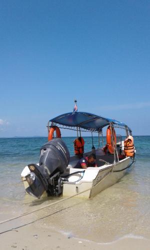 a boat on the beach with people on it at Rimba Resort - Dive Centre & Spa in Pulau Sibu