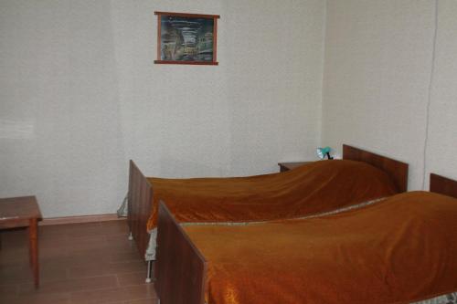 a bedroom with a bed with an orange blanket at TLT Guest House in Tʼelavi