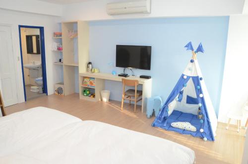 a bedroom with a room with a bed and a tv at 胖蝸牛親子民宿 in Tainan