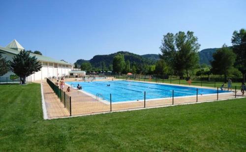 a large swimming pool with people sitting around it at Apartamento Sallan Ainsa Ordesa Zona Zero in Aínsa