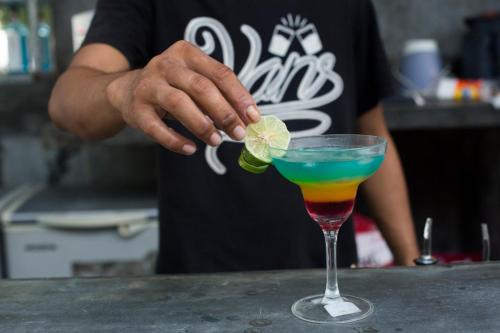 a person is putting a lime in a cocktail at Gili Beach Bum Hotel in Gili Trawangan