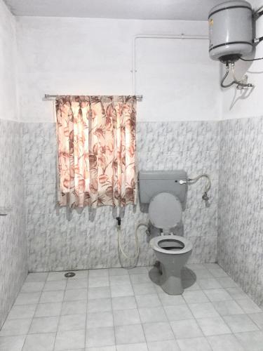 a bathroom with a toilet and a shower curtain at Maruti Villa in Kodaikānāl