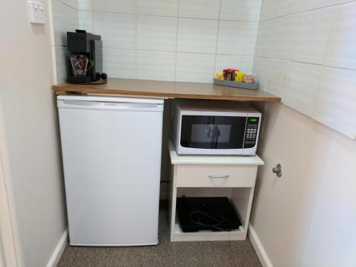 a small kitchen with a microwave and a refrigerator at Lake Bolac Motel in Lake Bolac