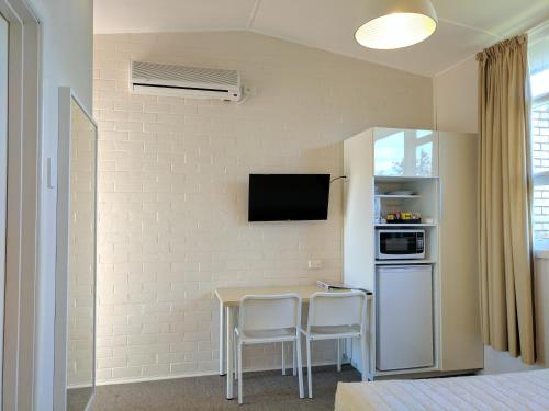 a small kitchen with a table and two chairs at Lake Bolac Motel in Lake Bolac