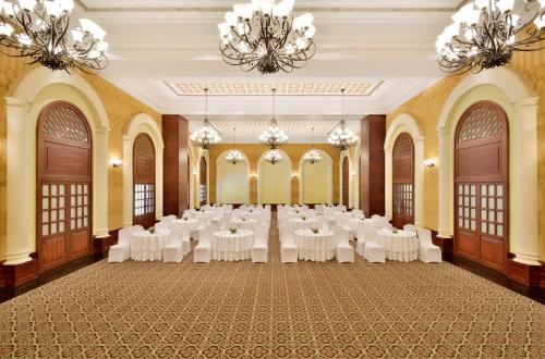 a banquet hall with white tables and chandeliers at Radisson Blu Resort, Goa in Cavelossim