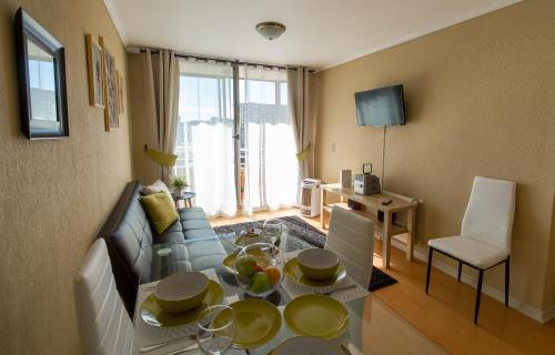 a living room with a couch and a table with plates on it at EcoApart Concepción in Concepción