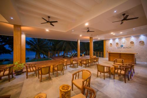 a restaurant with tables and chairs on a patio at Kiha Beach in Dharavandhoo