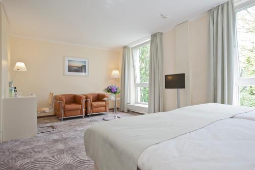 a hotel room with a bed and a couch at Michels Thalasso Hotel Nordseehaus in Norderney
