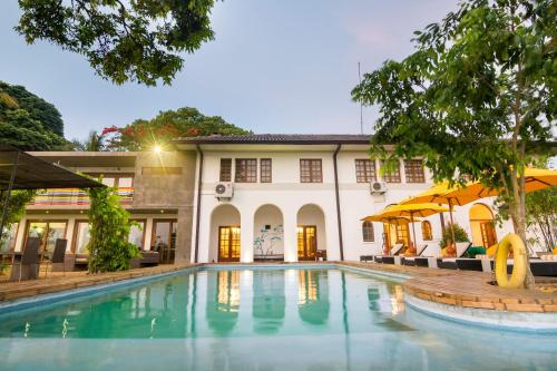 ein Schwimmbad vor einem Gebäude in der Unterkunft The Elephant Stables in Kandy